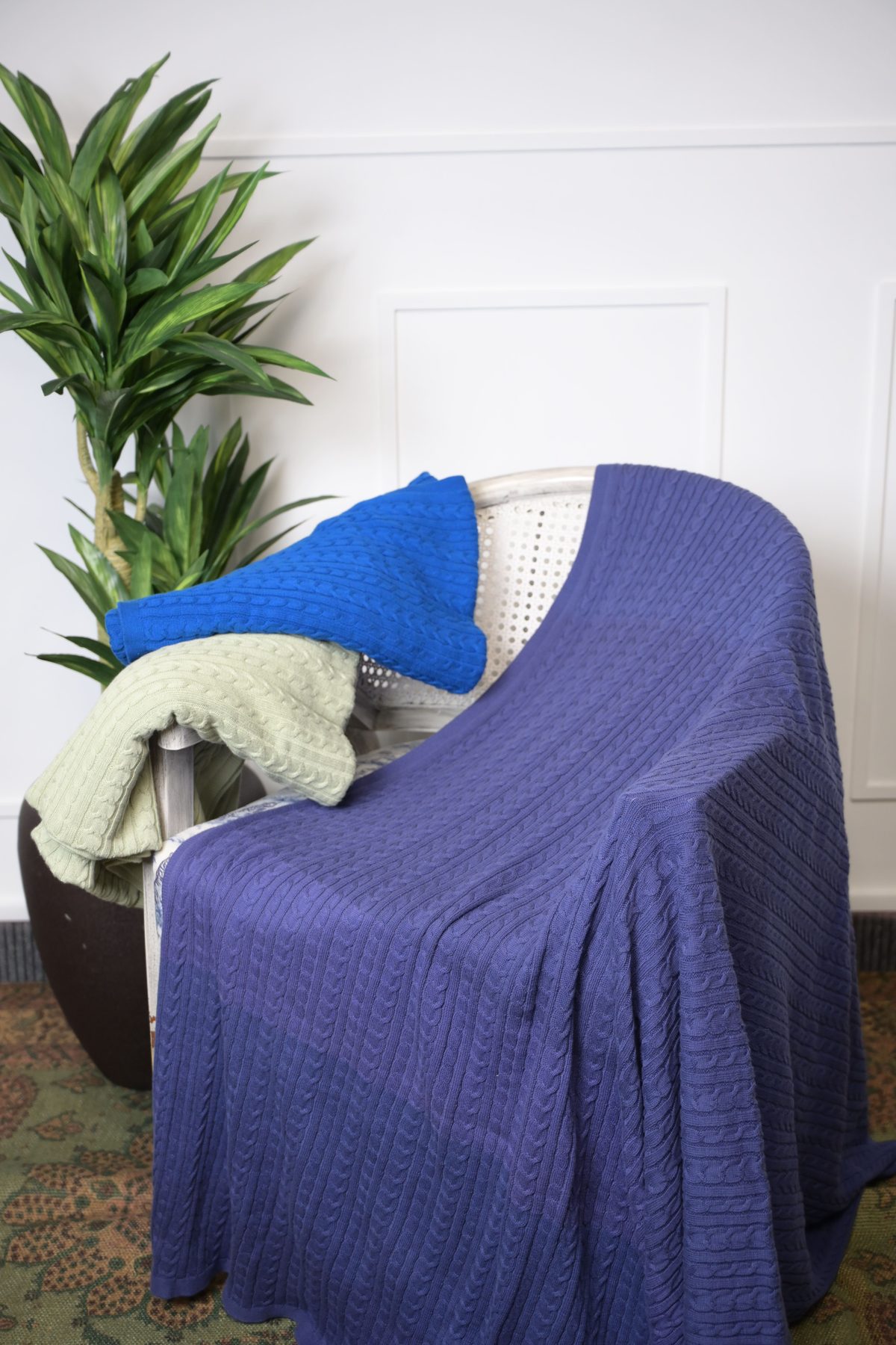 Navy, blue and sage throws styled on a chair